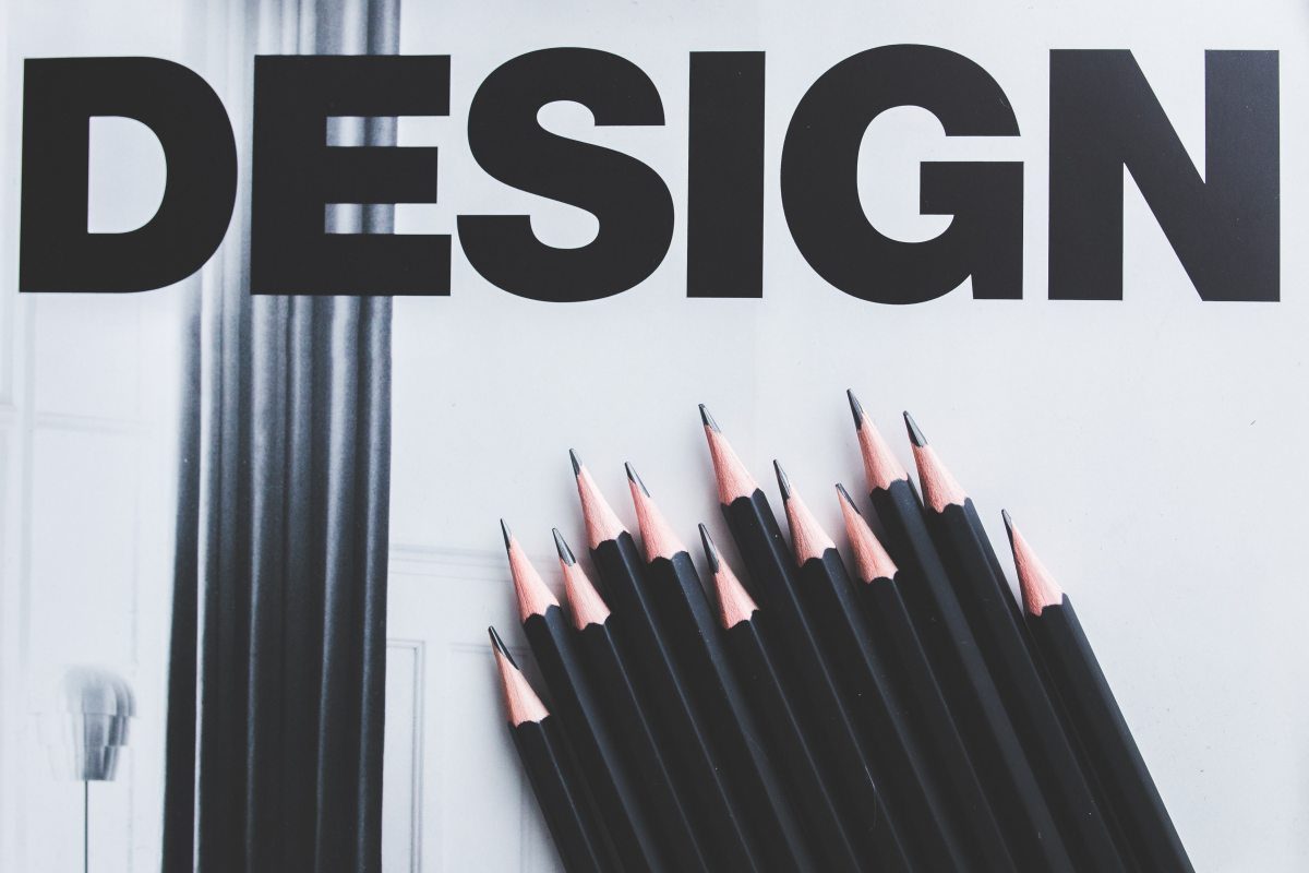 Black pencils arranged beside the word design