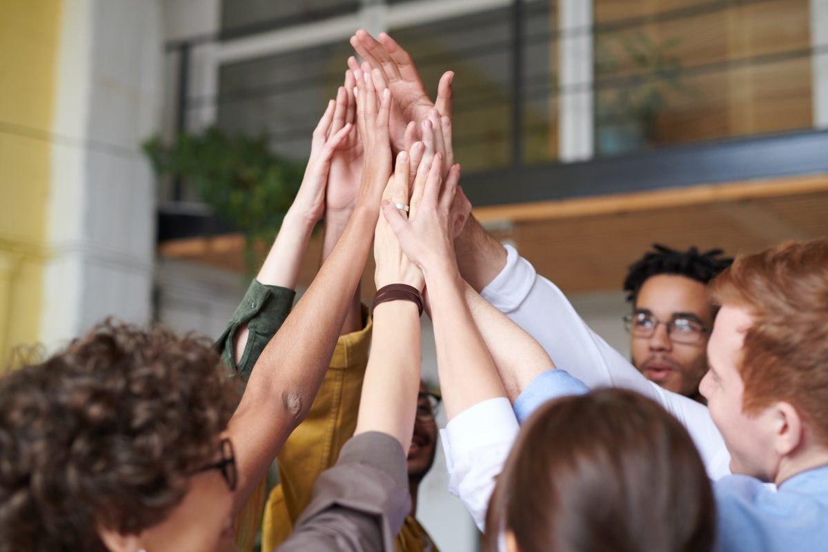 Several people resting their hands together on a table